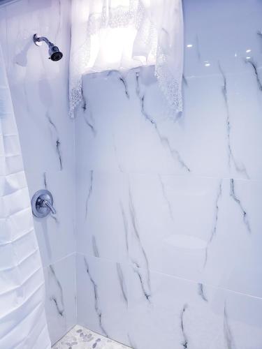 a bathroom with a shower with white marble at M/H HOUSE (#2) cozy house near airport and beach in Carolina