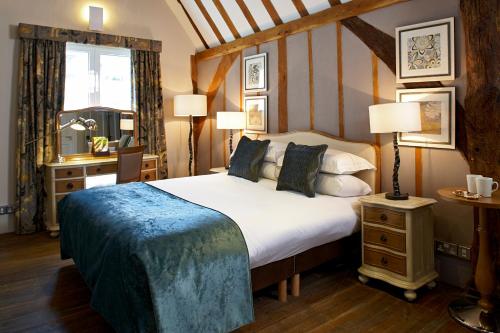 a bedroom with a bed and a desk and a window at Sir Christopher Wren Hotel in Windsor
