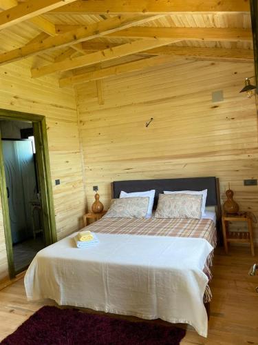 um quarto com uma cama num quarto de madeira em Lake Wood House em Muğla