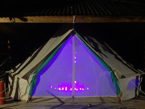 a tent that is lit up with purple lights at Cabanas de Nacpan Camping Resort in El Nido