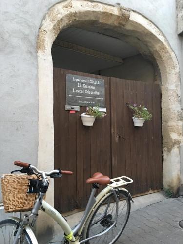 un vélo garé devant une porte en bois dans l'établissement Sololà, à Villeneuve-lès-Maguelone