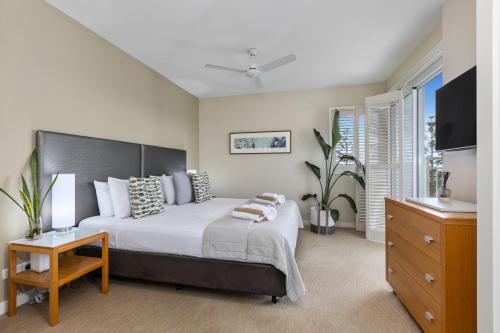 a bedroom with a large bed and a dresser at Salt - 2brm apartment with Spa bath and Ocean Views in Kingscliff