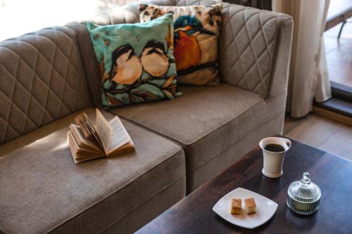 a living room with a couch and a table with a plate of food at StayVista at The Winter Line with Complimentary Breakfast in Kasauli
