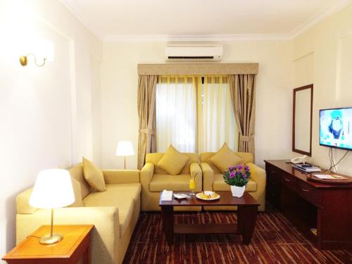 a living room with a couch and a table at Al Diar Mina Hotel in Abu Dhabi