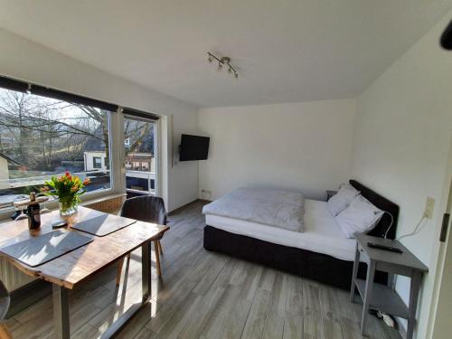 a bedroom with a bed and a table and a window at Apartement Willingen in Stryck
