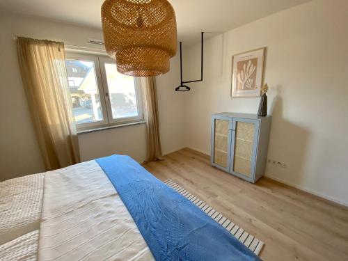 een slaapkamer met een blauw bed en een raam bij Ferienwohnung Am bayrischen Meer in Übersee