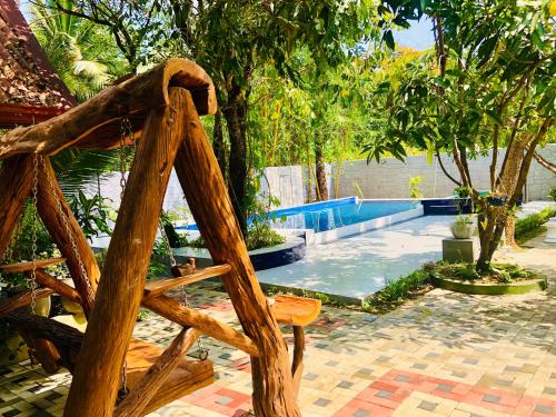 a wooden chair in front of a swimming pool at Bangalawa Resort in Habarana