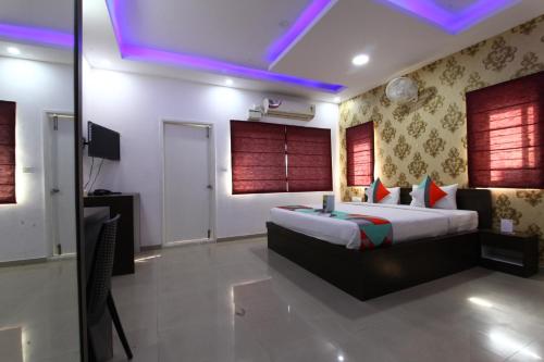 a bedroom with a bed and a tv in it at Avenue Inn in Bangalore