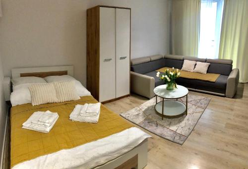 sala de estar con 2 camas y sofá en Apartament Rzeszów Centrum, en Rzeszów