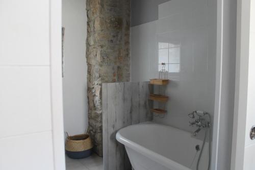 Baño blanco con bañera y lavamanos en La Bastide de Margoline en Lagrasse