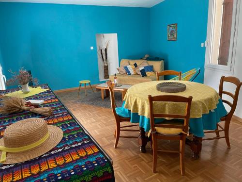 une chambre bleue avec une table, des chaises et un canapé dans l'établissement Sololà, à Villeneuve-lès-Maguelone