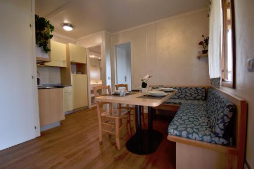 a small room with a table and a kitchen at Agriturismo B&B Corte Tonolli in Valeggio sul Mincio