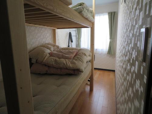 a bedroom with a bunk bed in a room at Sapporo Guest House Nariya in Sapporo