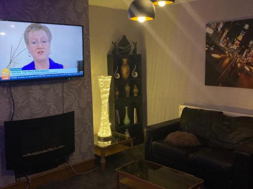 uma sala de estar com um sofá e uma televisão de ecrã plano em Trevor And The Cats em Mansfield