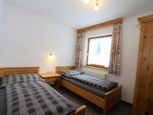 two beds in a room with a window at Apartment in Ischgl overlooking the mountains in Ischgl