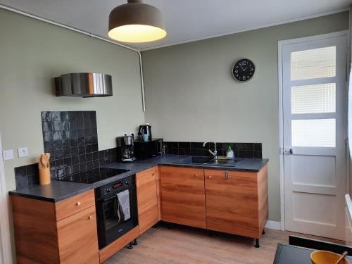 - une cuisine avec des comptoirs noirs et un évier dans l'établissement Chambre2 dans coloc de 75m2, à Troyes