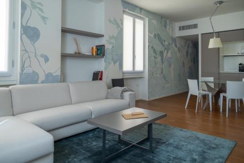 Ariosto Social Club في ميلانو: غرفة معيشة مع أريكة بيضاء وطاولة