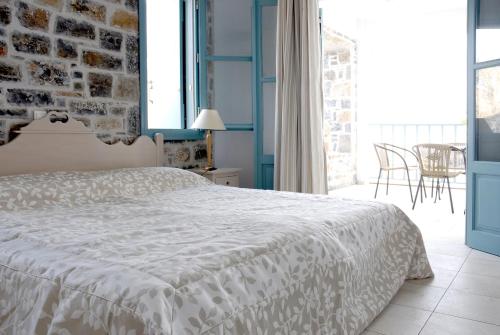 a bedroom with a white bed and a brick wall at Mohlos Villas in Mochlos