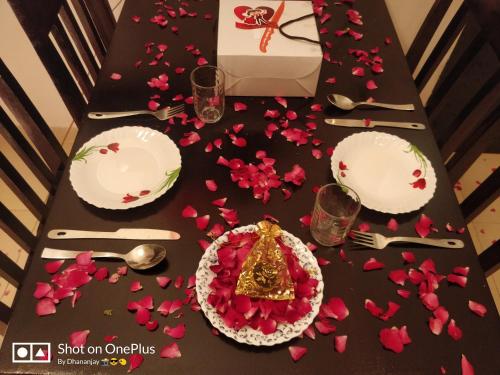 a black table with pink flower petals on it at Chalet Casa Amor, Perfect home amidst tranquility in Karjat