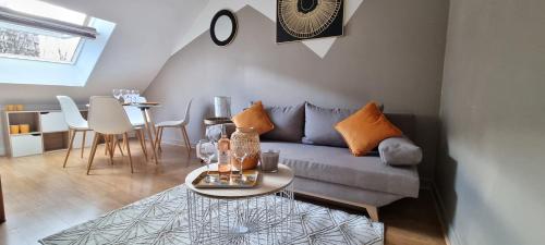 un salon avec un canapé et une table dans l'établissement La Résidence K-méléon- Hyper centre , 23 couchages, au Mans