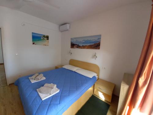 a small bedroom with a blue bed in a room at Apartments Vinko in Sobra