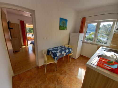 a kitchen with a table and chairs in a room at Apartments Vinko in Sobra