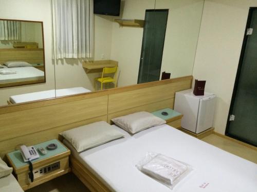 Cette chambre comprend un lit et un grand miroir. dans l'établissement Hotel Encontros (Adult Only), à Rio de Janeiro