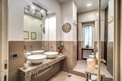 a bathroom with two sinks and two mirrors at Gianicolo Miracle Suite in Rome