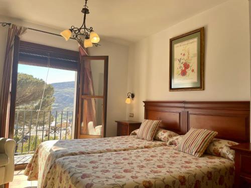 a bedroom with a bed and a large window at Hotel Rural Poqueira II in Capileira