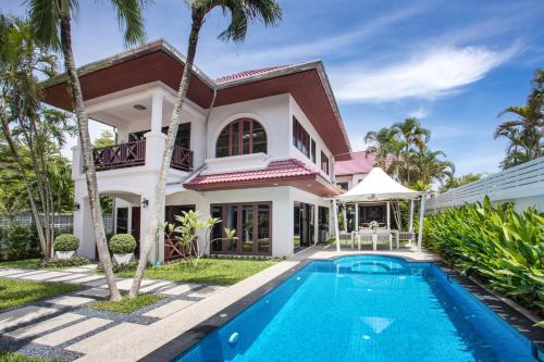 a villa with a swimming pool in front of a house at Best Holidays - Oxygen pool, Billard, Gym! 2-Storey Tropical Villa Havana N in Kamala Beach
