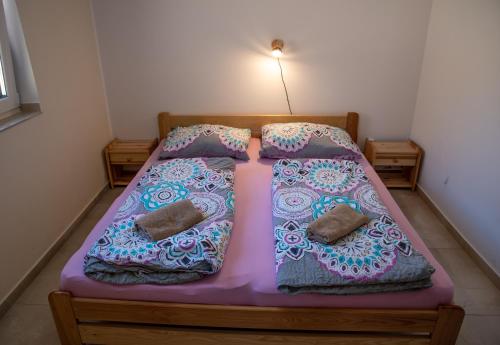 a bedroom with a pink bed with two pillows at Chata U dědka in Prostřední Bečva