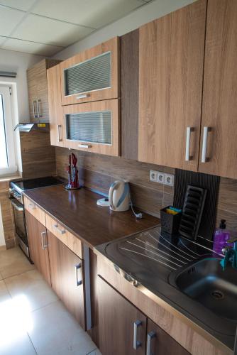 a kitchen with a sink and wooden cabinets at Chata U dědka in Prostřední Bečva