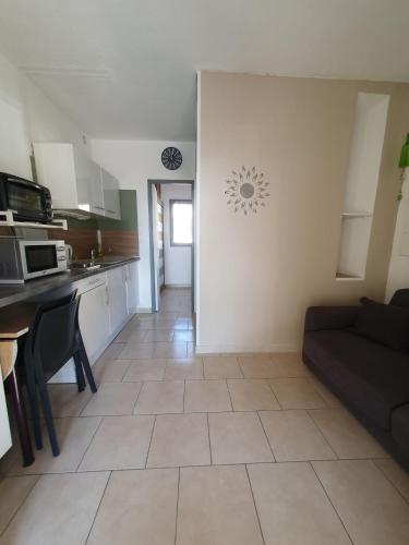 un salon avec un canapé et une cuisine dans l'établissement Apartment Saint Saens, à Marseillan
