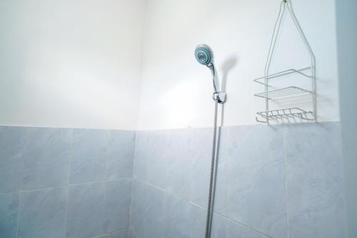 a shower with a shower head in a bathroom at Pekayon Garden House Syariah RedPartner in Pekayon Dua