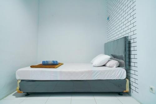een bed in een kamer met een witte muur bij Pekayon Garden House Syariah RedPartner in Pekayon Dua