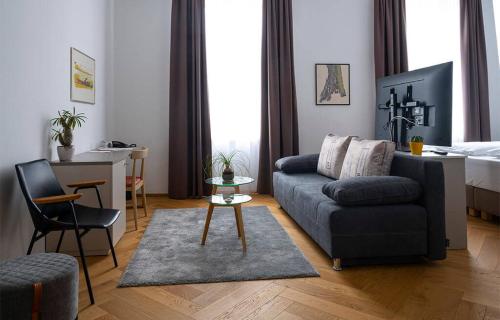 uma sala de estar com um sofá e uma cama em Hotel Belmur em Murska Sobota