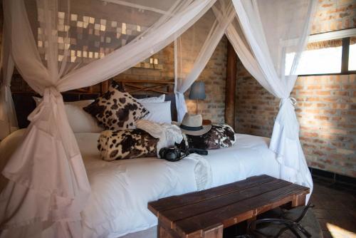 a bedroom with a white bed with a canopy at Morakane Safari Lodge in Vryburg