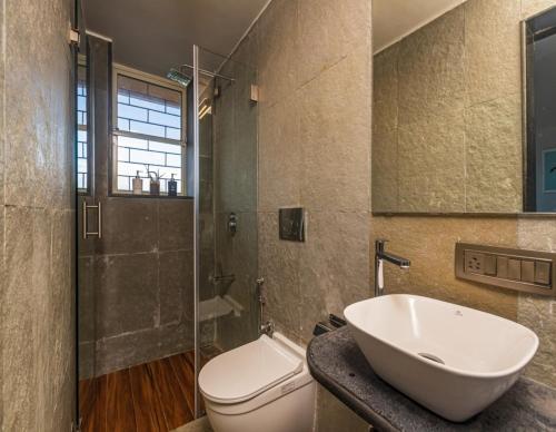 uma casa de banho com um lavatório, um WC e um chuveiro em SaffronStays Blue Infinitum, Pawna em Lonavala