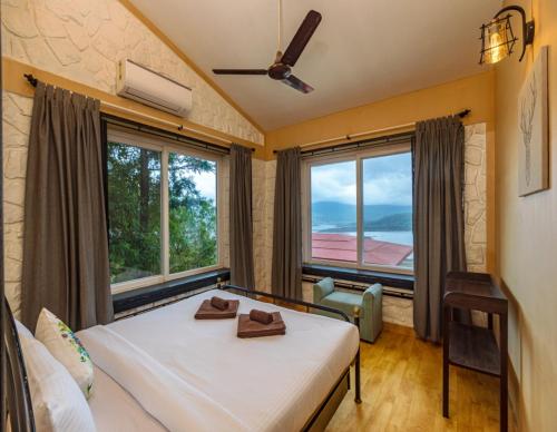 a bedroom with a bed and a large window at SaffronStays Blue Infinitum, Pawna in Lonavala