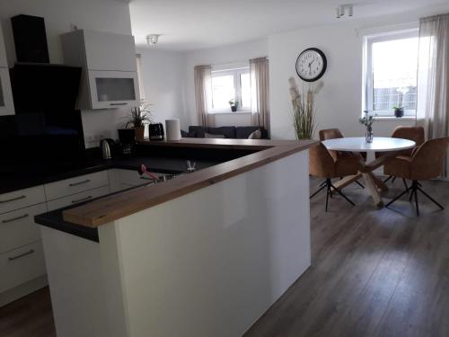 a kitchen and living room with a clock on the wall at Appartments Eutiner Seepark in Eutin