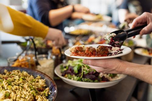 a group of people holding plates of food on a table at Best Western Plus Hotel Fredericia in Fredericia