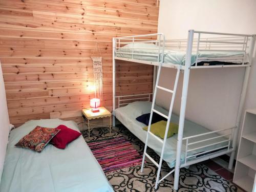 two bunk beds in a room with a wooden wall at Gîte de charme au coeur de Ruoms avec terrasse in Ruoms