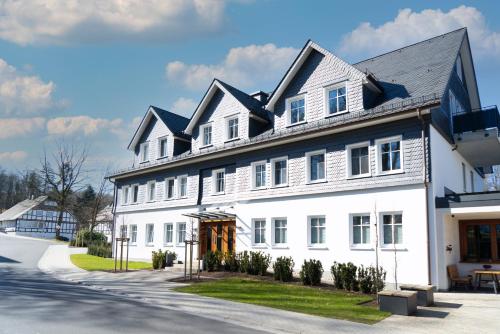 a large white house with a black roof at Hawerländer Apartments in Schmallenberg