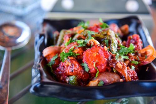 a black dish of food with meat and vegetables at Hotel Casa by the lake in Udaipur