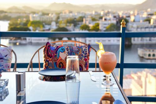 a table with a glass of beer on a balcony at Hotel Casa by the lake in Udaipur
