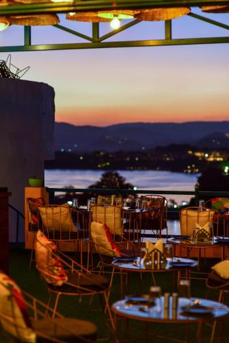 a group of tables and chairs on a balcony at sunset at Hotel Casa by the lake in Udaipur