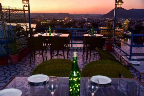 a patio with tables and chairs with a view of the city at Hotel Casa by the lake in Udaipur