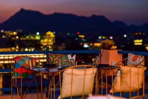 a table and chairs on a balcony at night at Hotel Casa by the lake in Udaipur