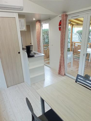 une cuisine avec une table et une porte menant à une terrasse dans l'établissement camping 4 étoiles le lac des rêves, à Pérols