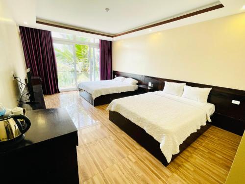 Habitación de hotel con 2 camas y ventana grande. en Tuan Chau Havana Hotel, en Ha Long